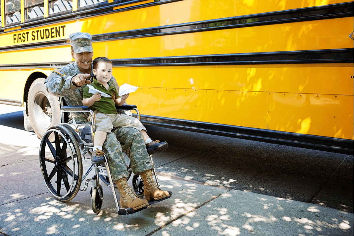 military dad in wheelchair holds child by school bus