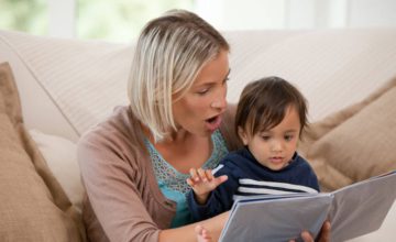 A boy and mom sit together and read a book