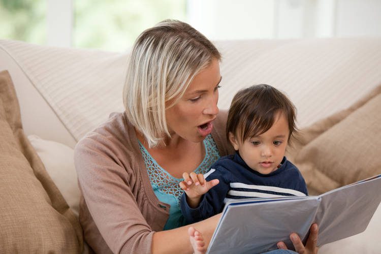 A boy and mom sit together and read a book
