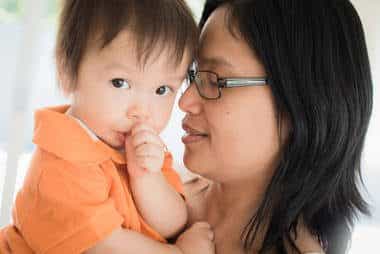 mom holds baby in orange shirt