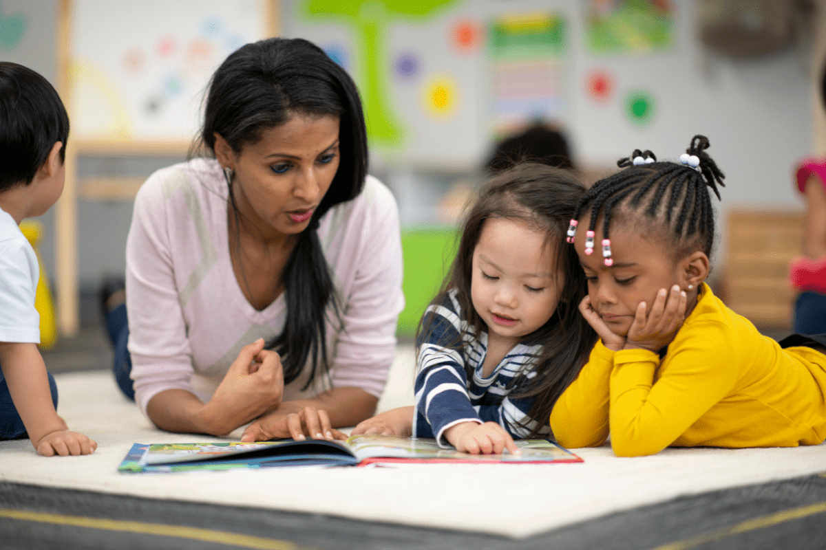 adult reads book to two kids