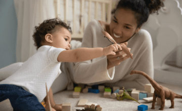 mom and baby play with dinosaur toys