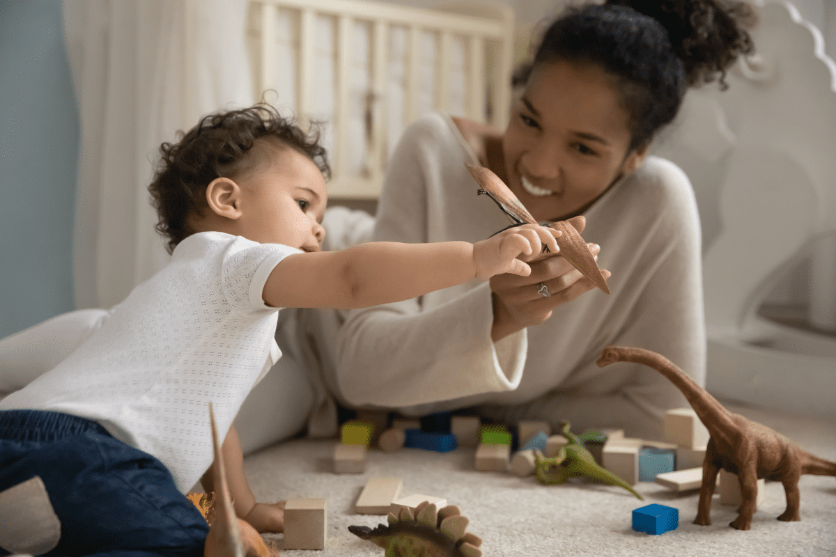 mom and baby play with dinosaur toys