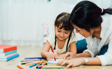 mom and daughter color with pencils on floor