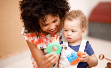 woman shows green ring to baby