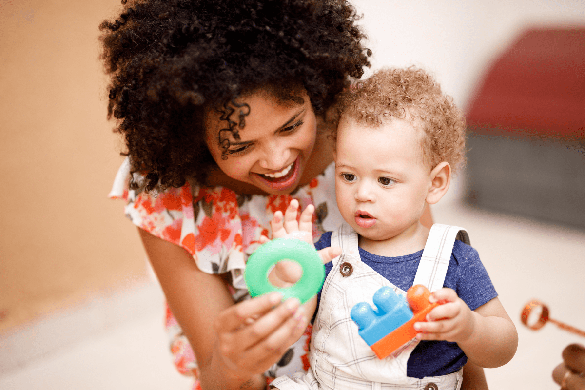 woman shows green ring to baby