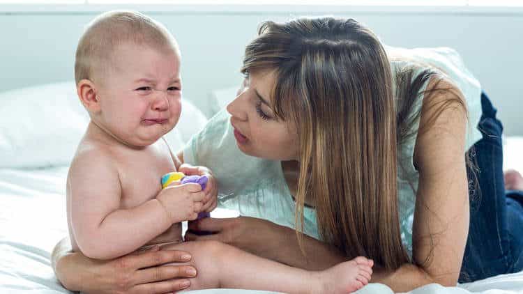 mom comforts crying baby