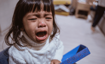 little girl crying with a box