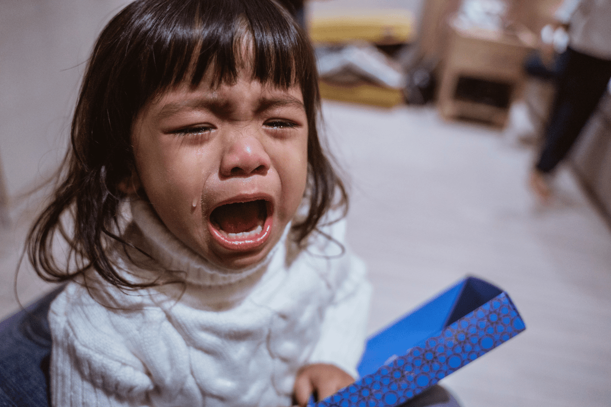 little girl crying with a box