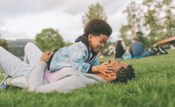 father and son on grass. black family