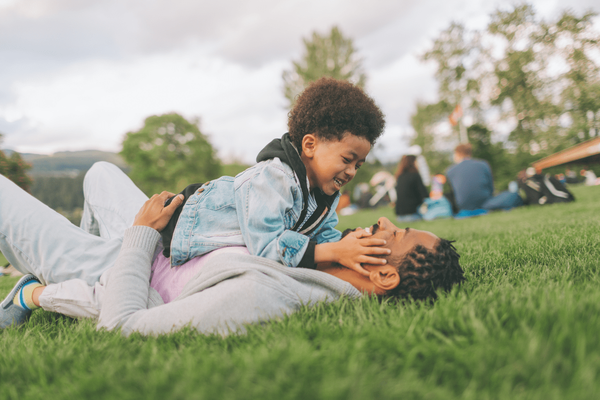 father and son on grass. black family