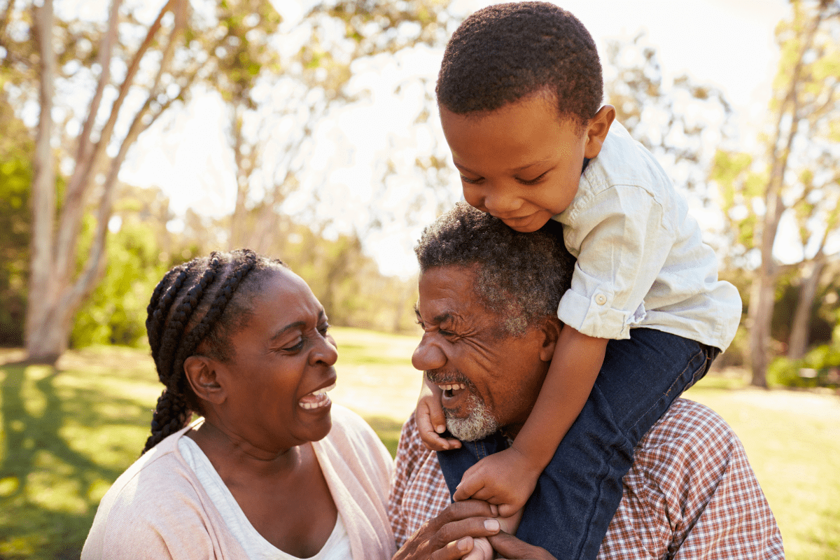 grandpa carries grandson on shoulders at park