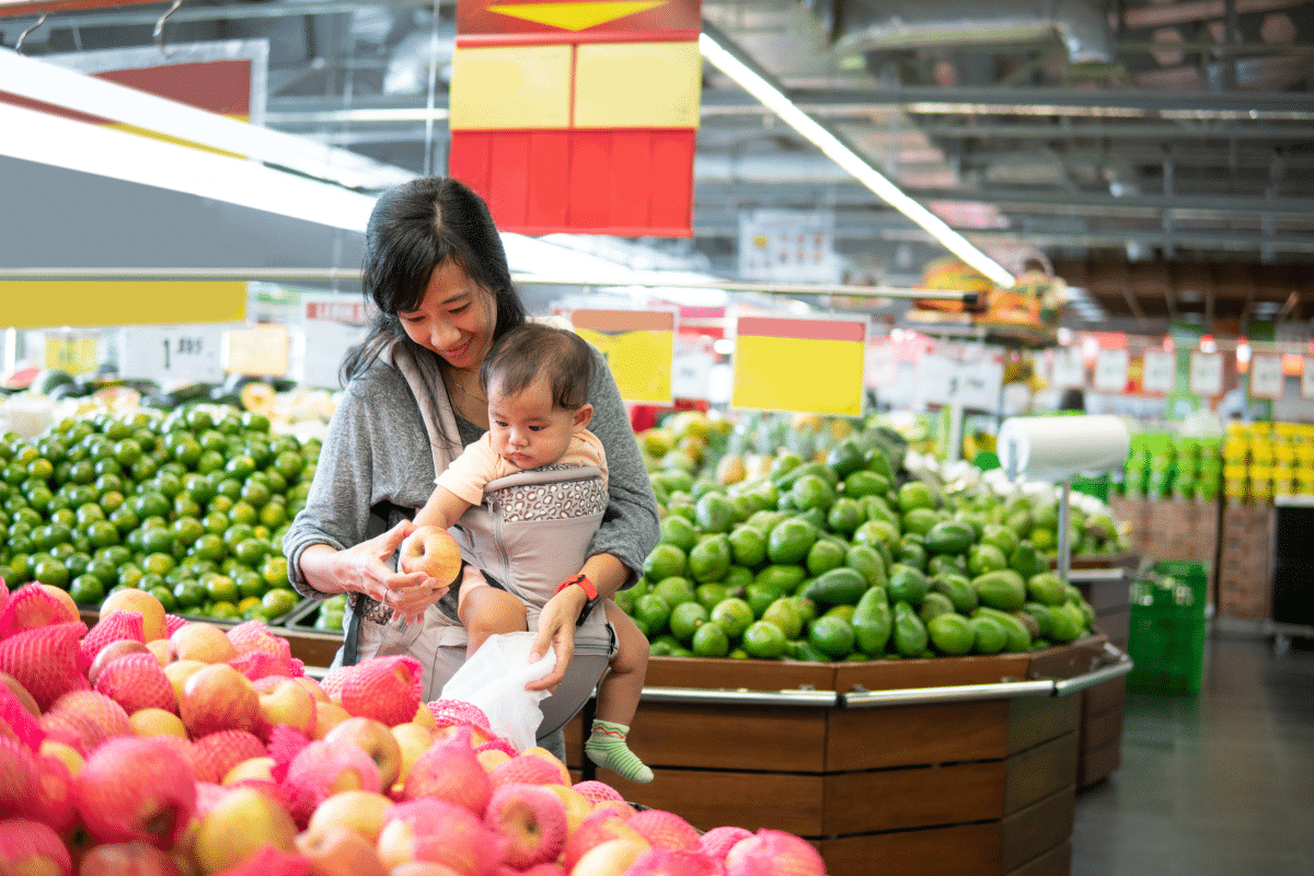 mom buys apples at grocery store