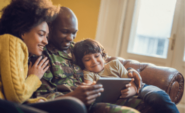 military dad with wife and son on couch with tablet