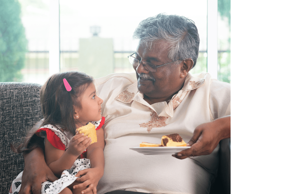 grandpa gives granddaughter food on couch