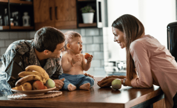 military dad in kitchen with wife and baby