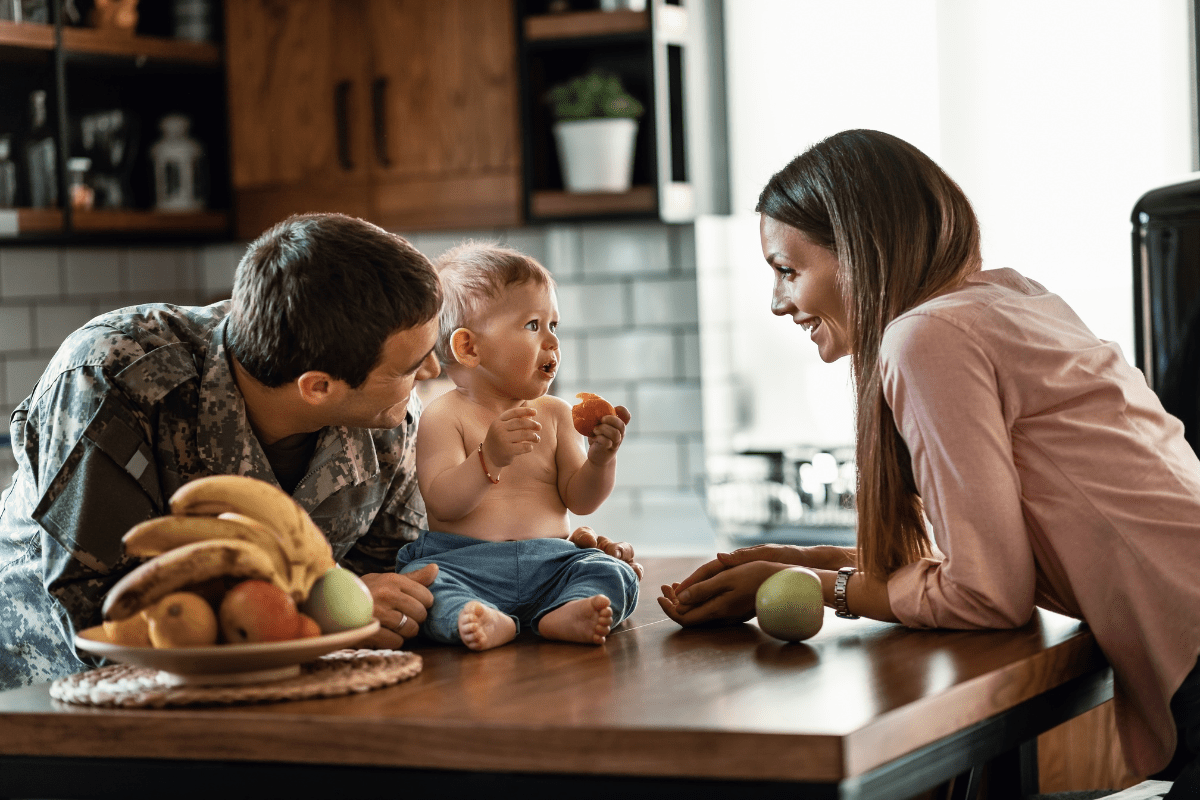 military dad in kitchen with wife and baby