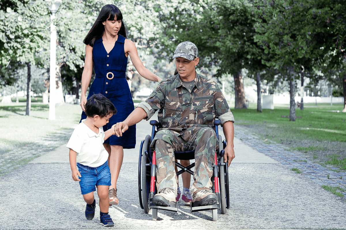 veteran dad in wheelchair holds son's hand