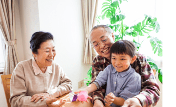 Grandparents smile at child at table