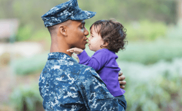 military dad kisses daughter wearing purple