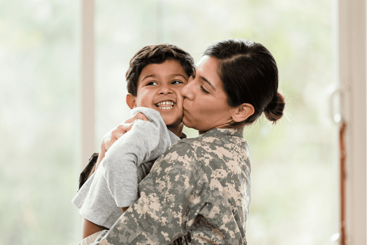 military mom kisses and hugs son