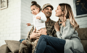 military dad on couch with wife and baby