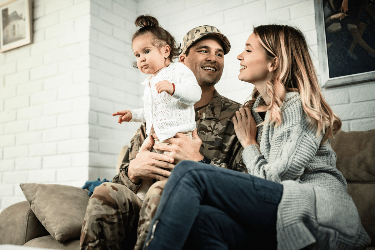 military dad on couch with wife and baby