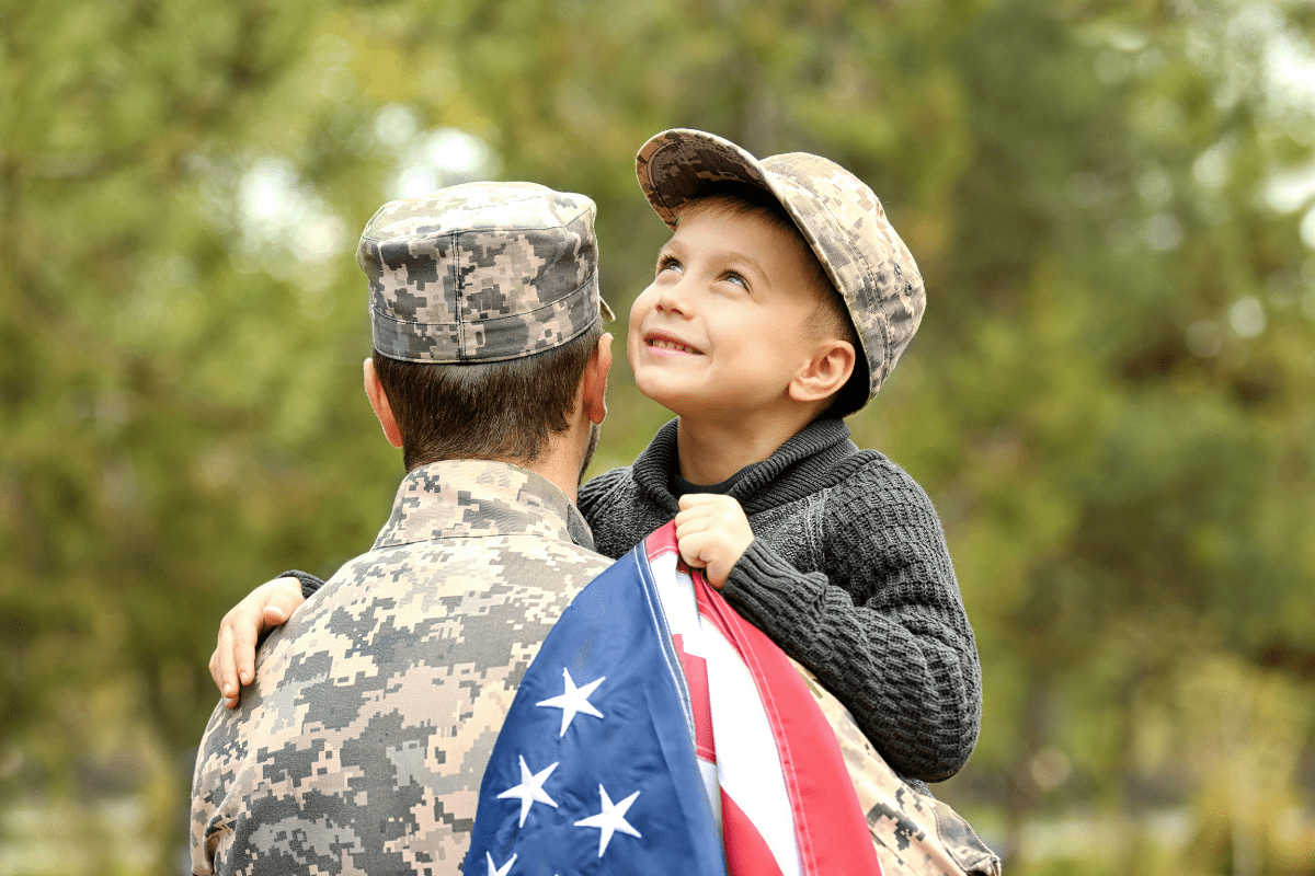 military dad with son carrying American flag
