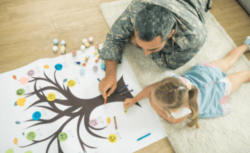military dad and daughter drawing on floor