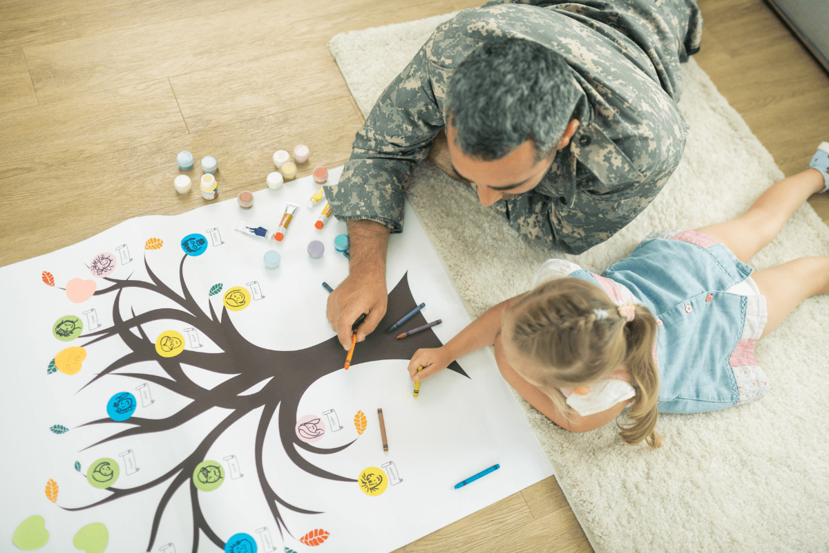 military dad and daughter drawing on floor