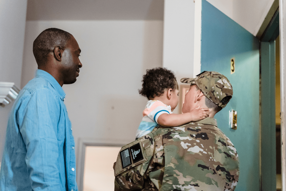 military mom holds baby next to husband in blue