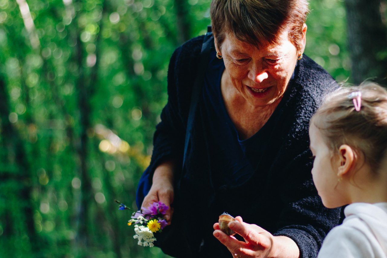 grandma shows child flowers outside