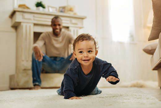 Baby learning to crawl with dad