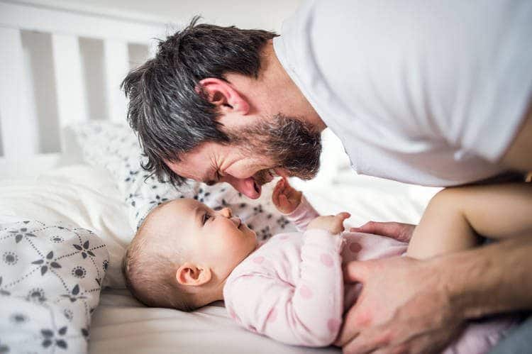 dad and baby smiling at each other