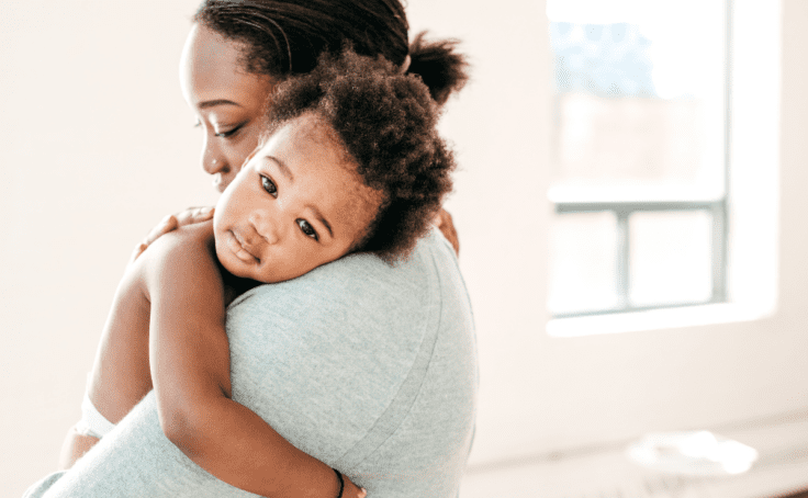 mom holding baby on her shoulder