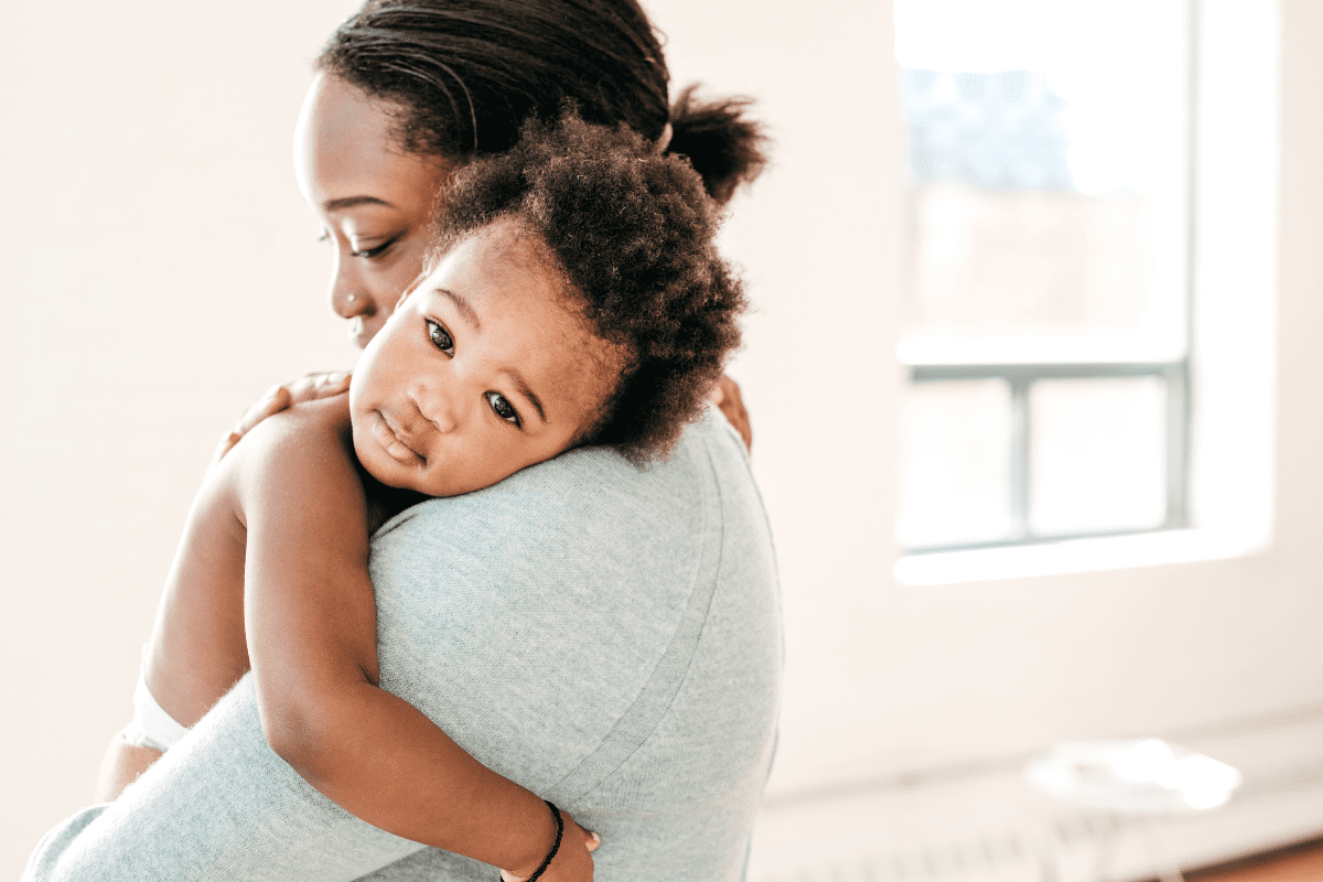 mom holding baby on her shoulder