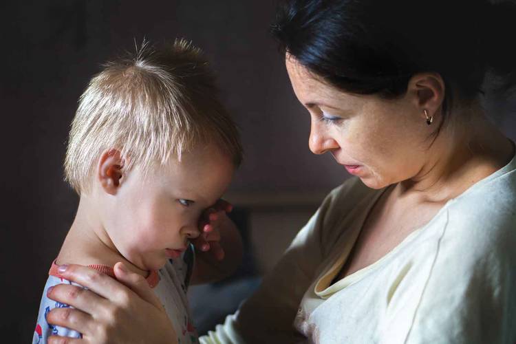 A woman offers comfort to a crying child.