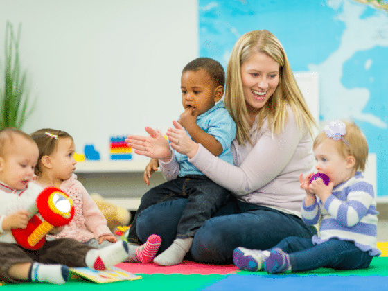 daycare woman smiles at four children
