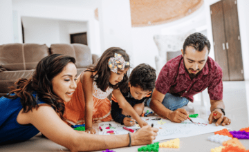 parents and two kids color on the floor