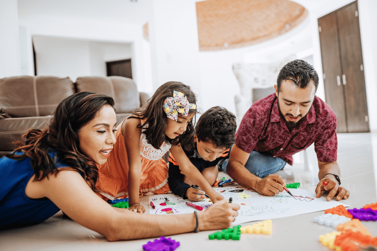 parents and two kids color on the floor