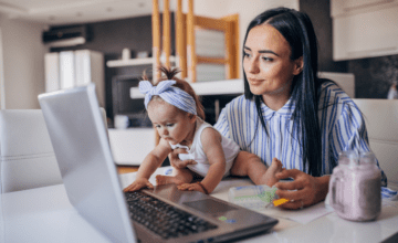 mother in blue with baby and laptop