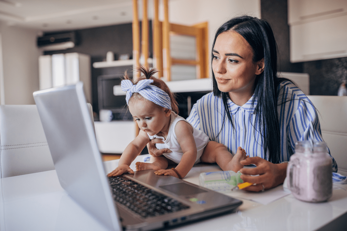 mother in blue with baby and laptop