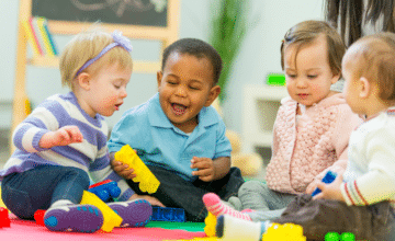 four babies play with blocks