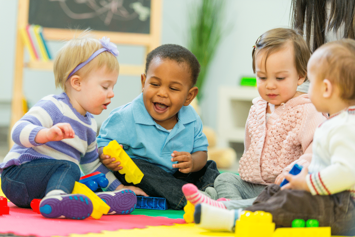 four babies play with blocks