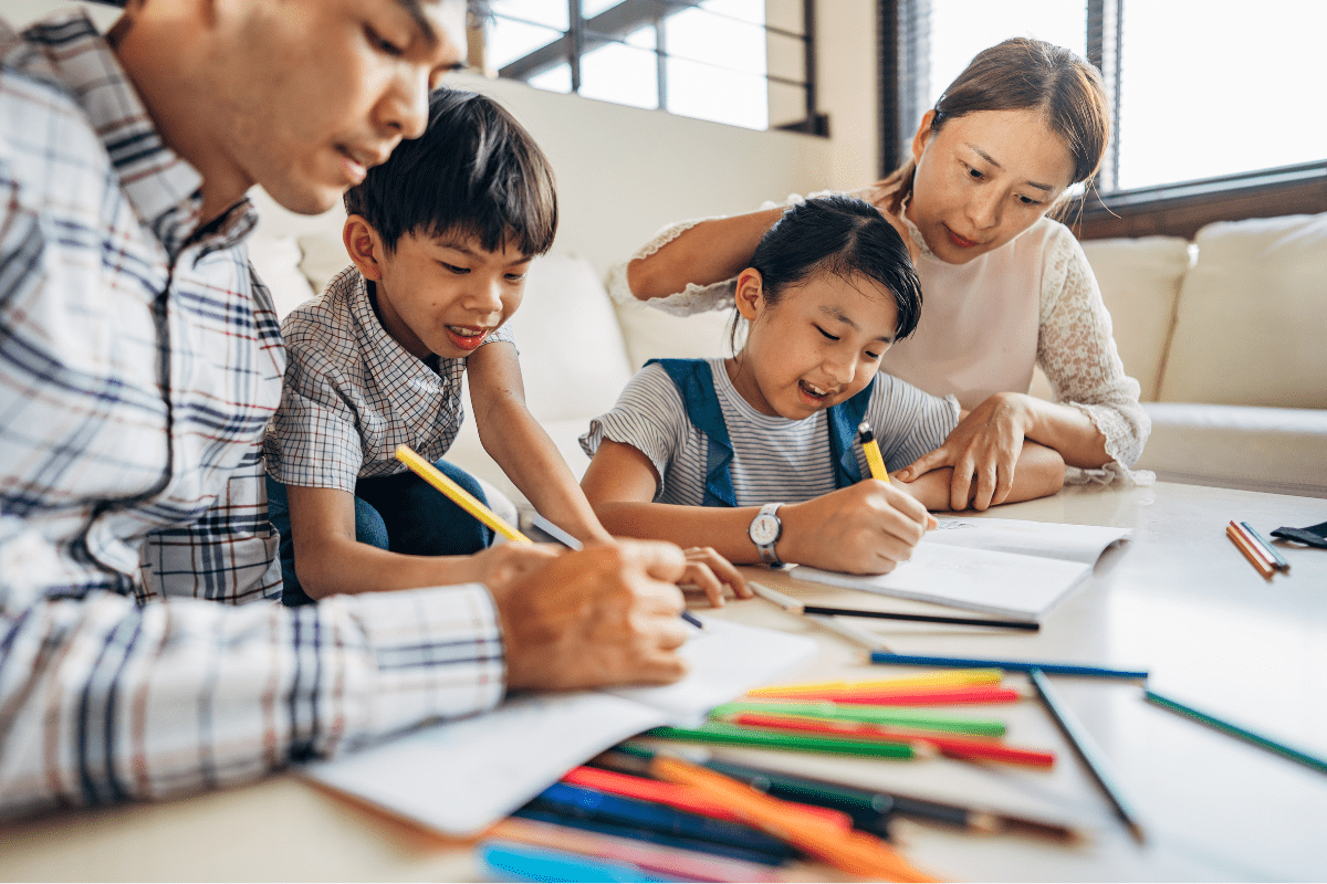 parents and two children draw with color pencils