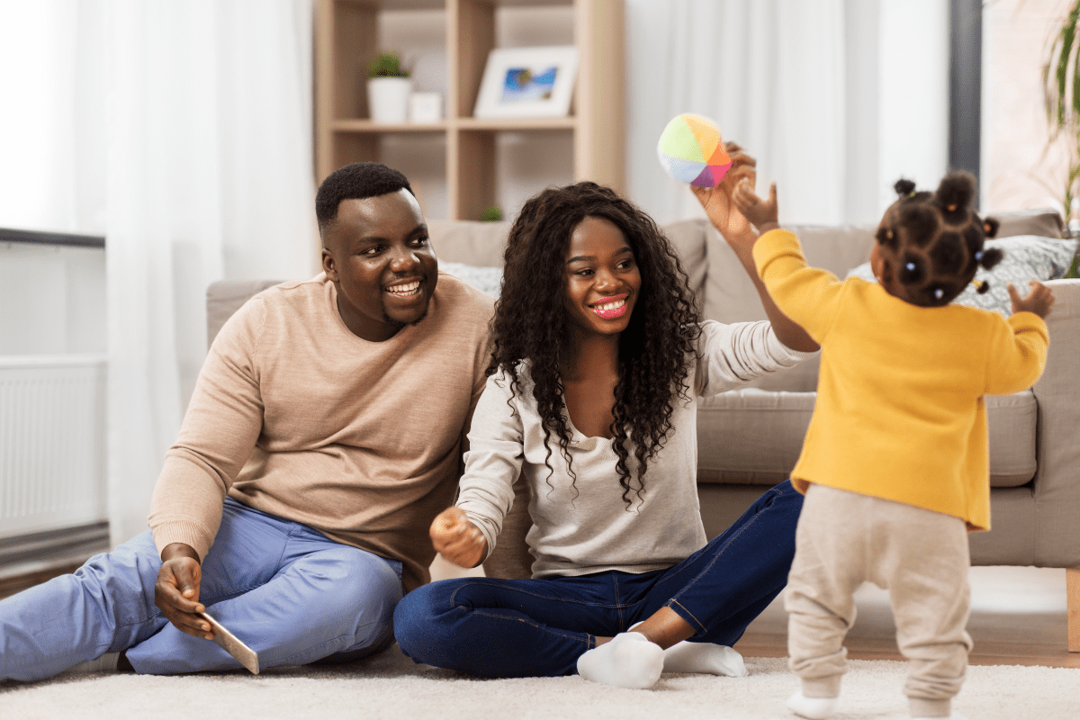 parents play with daughter in living room