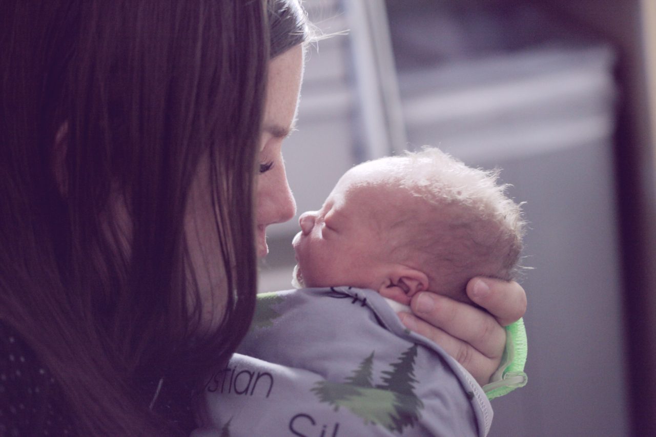 mother touches nose with newborn