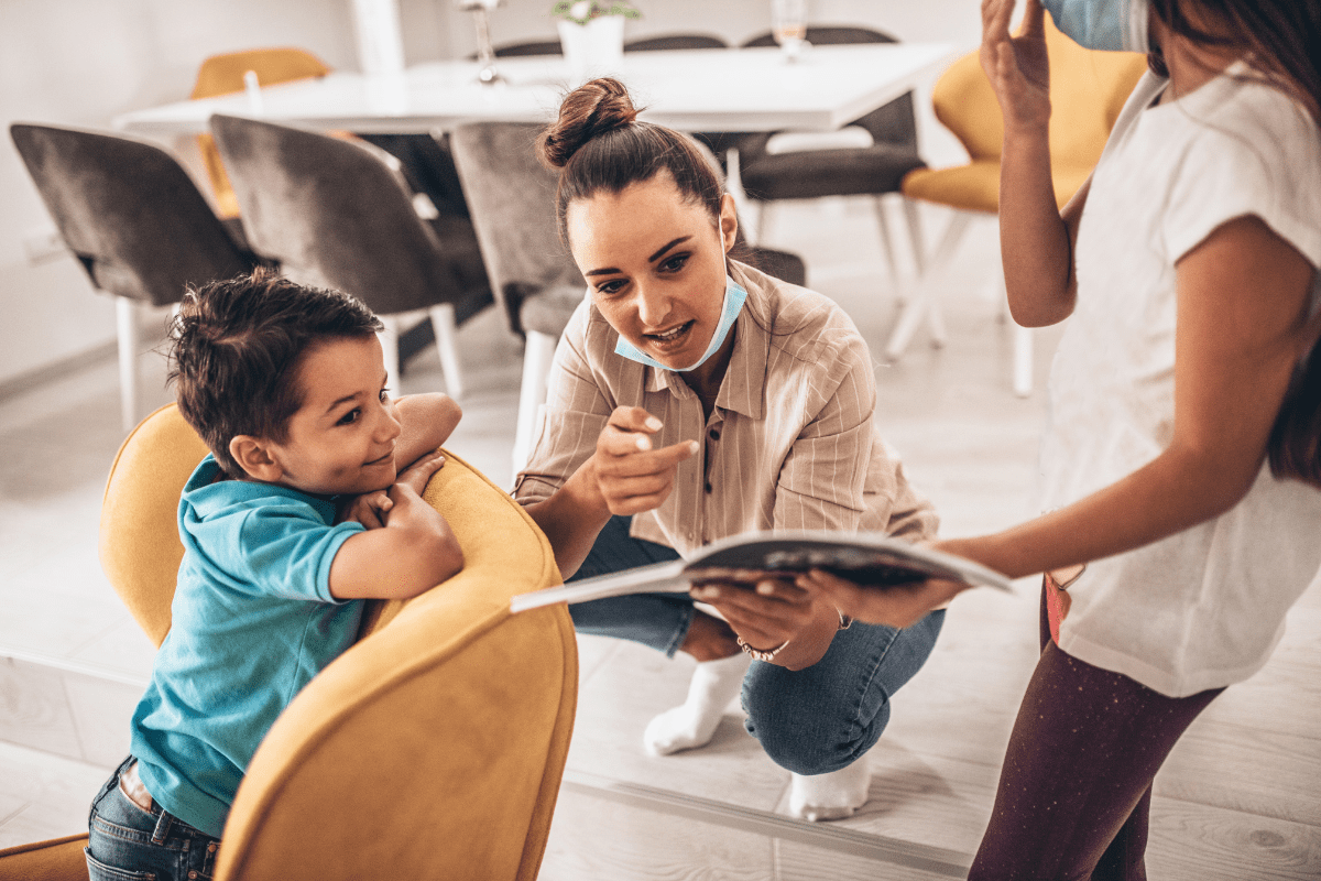 adults with masks show child a book