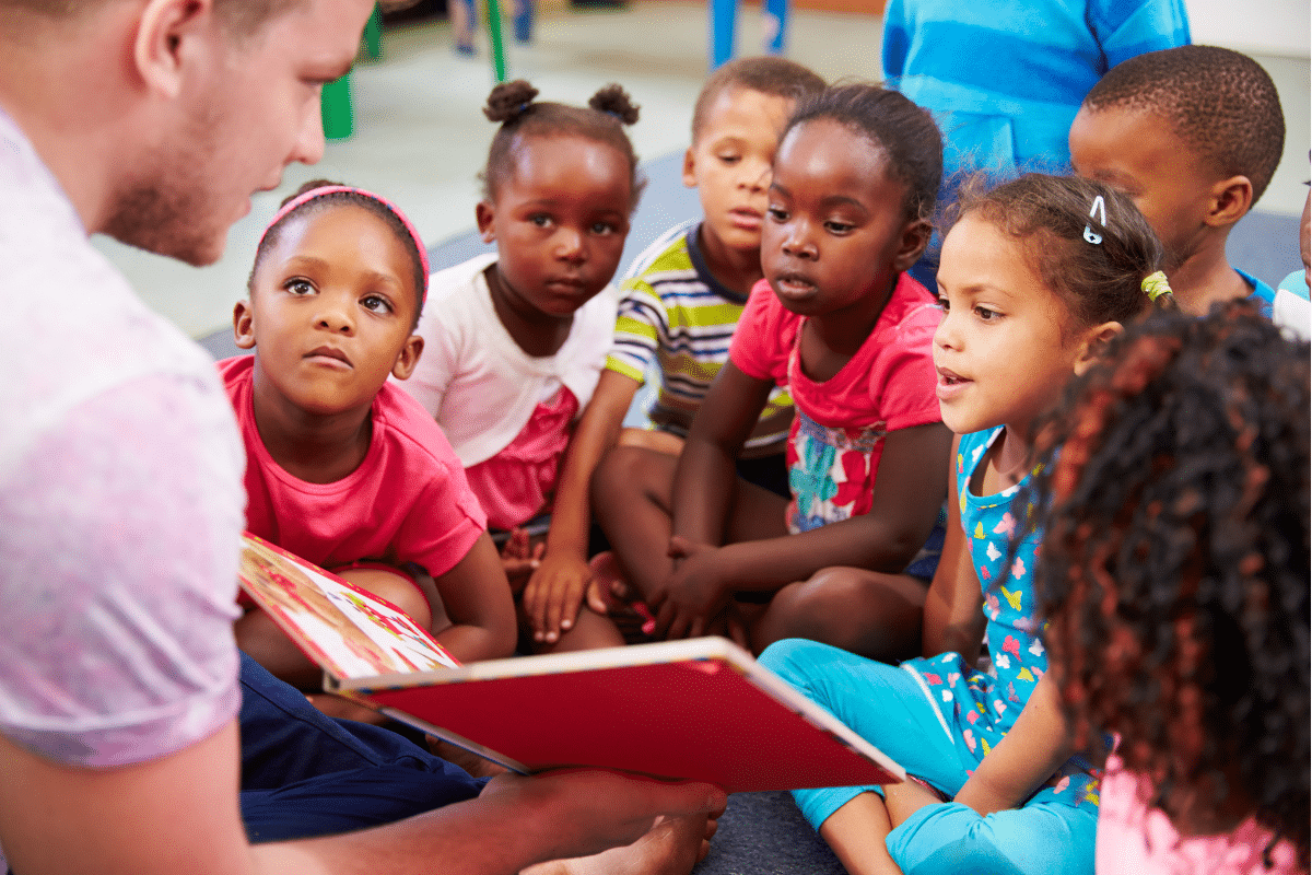 Man reads book to group of children