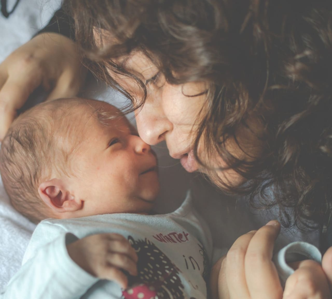 mom and infant nuzzle noses